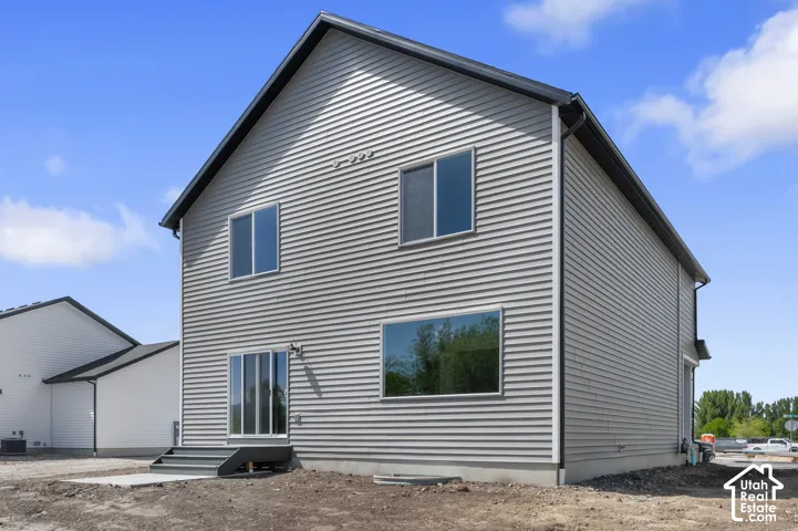 Two-story property with horizontal siding, a dark pitched roof, sliding glass door, and multiple windows