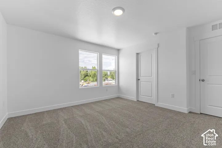 Recessed ceiling light fixture, two pane windows, textured gray carpet, and white paneled doors