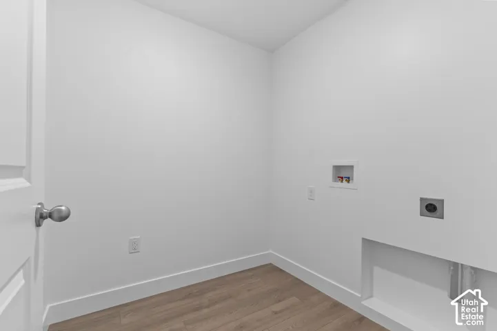 Utility space featuring wood-finish flooring, white walls, and dedicated appliance hookups