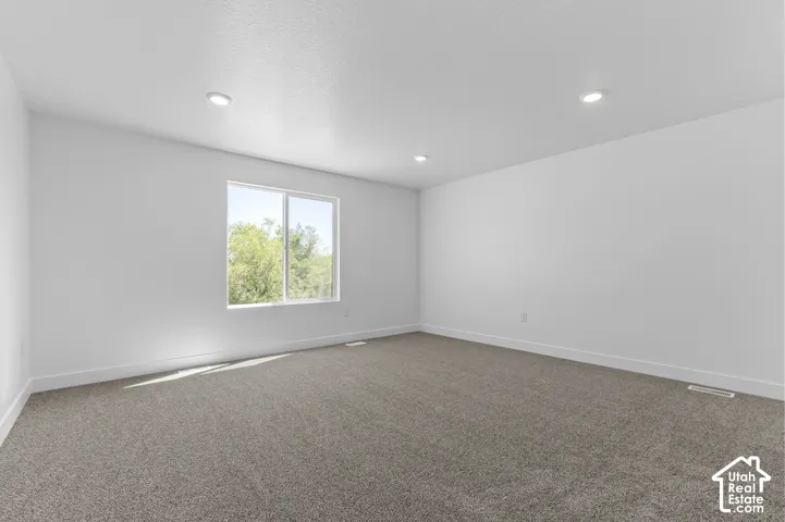 Recessed lighting and a large window set in a light-toned wall