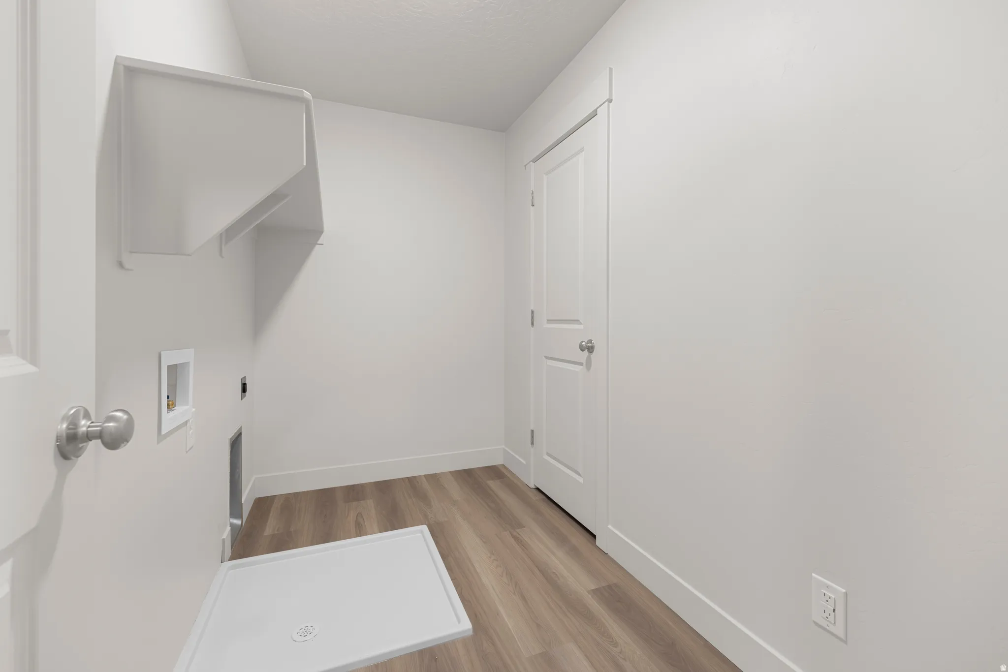 Laundry area with light wood finished floors, washer hookup, and electric dryer hookup