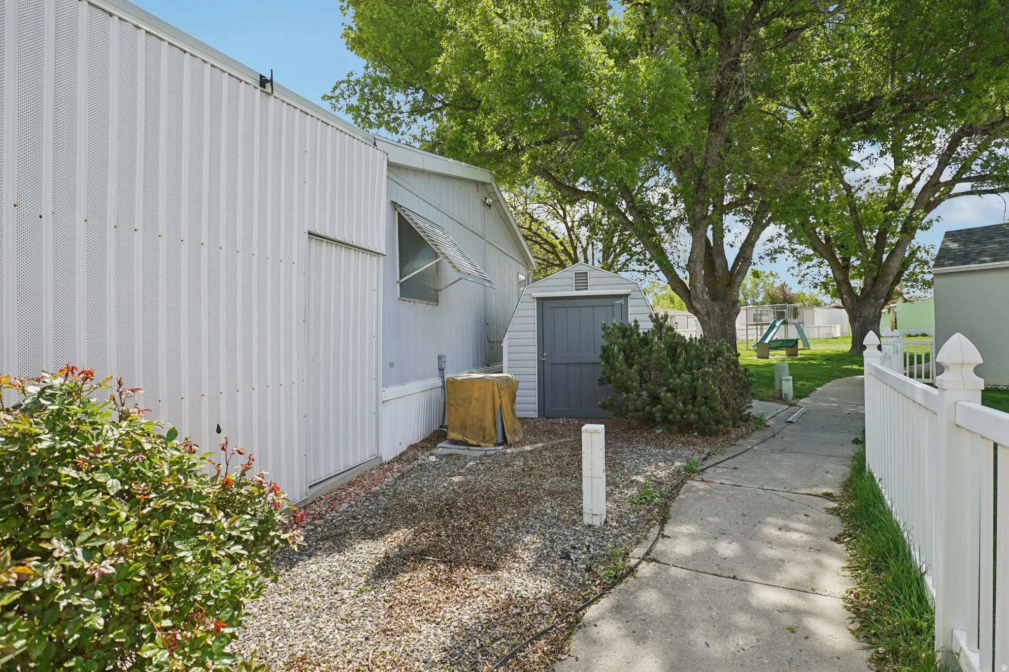 View of property exterior with a storage unit and a playground