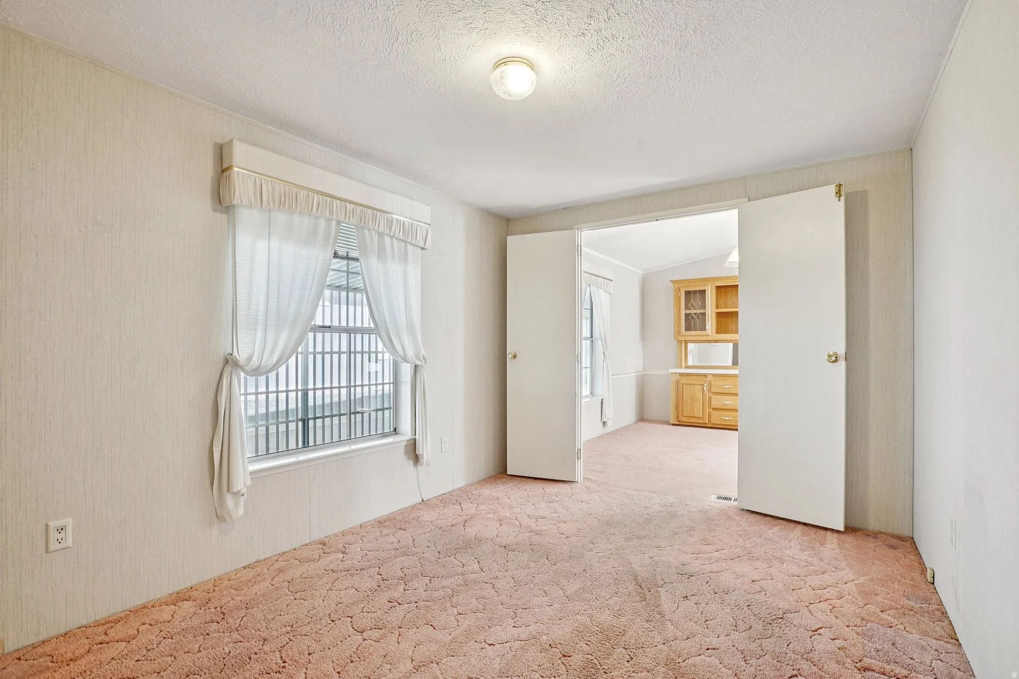 Unfurnished room featuring light carpet and a textured ceiling