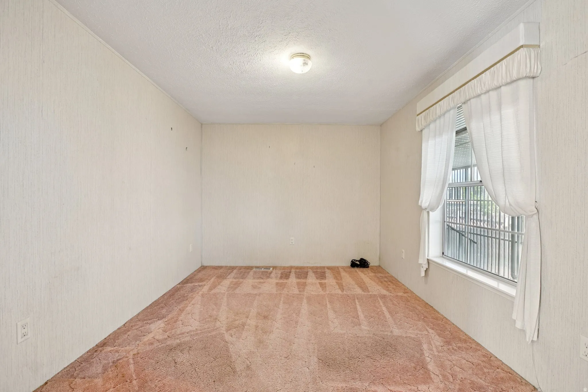 Carpeted spare room featuring a textured ceiling