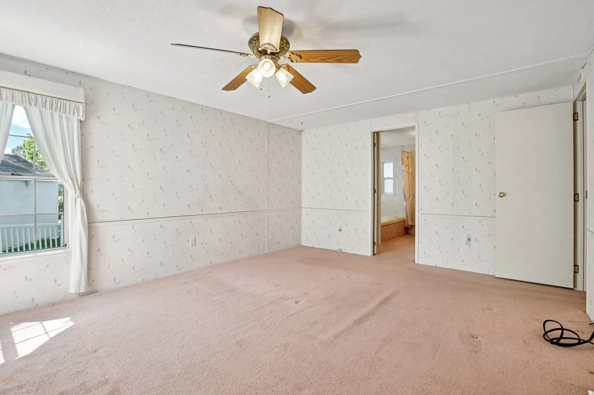 Unfurnished bedroom featuring multiple windows, carpet floors, and ceiling fan