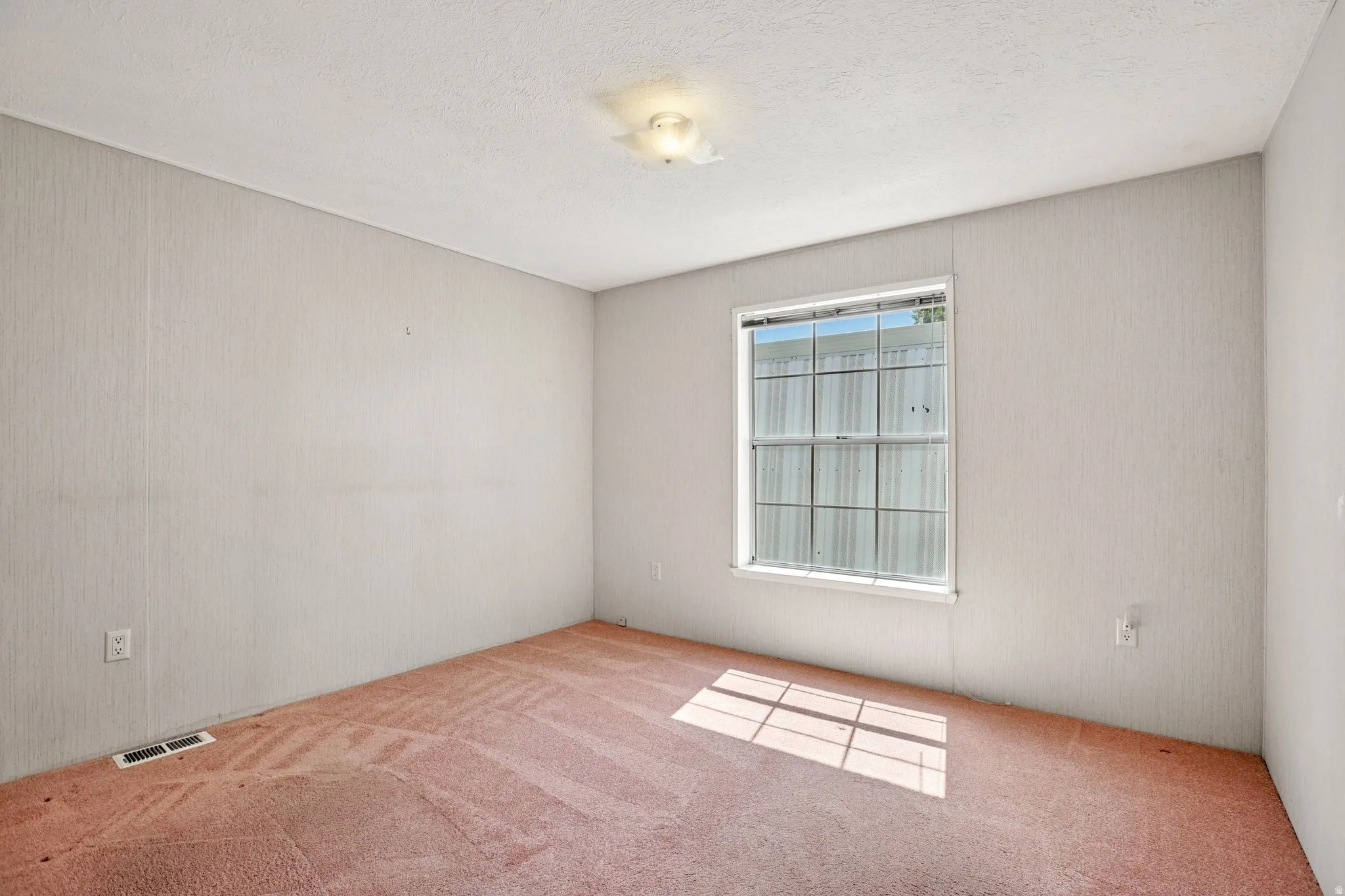 Empty room featuring carpet floors and a textured ceiling