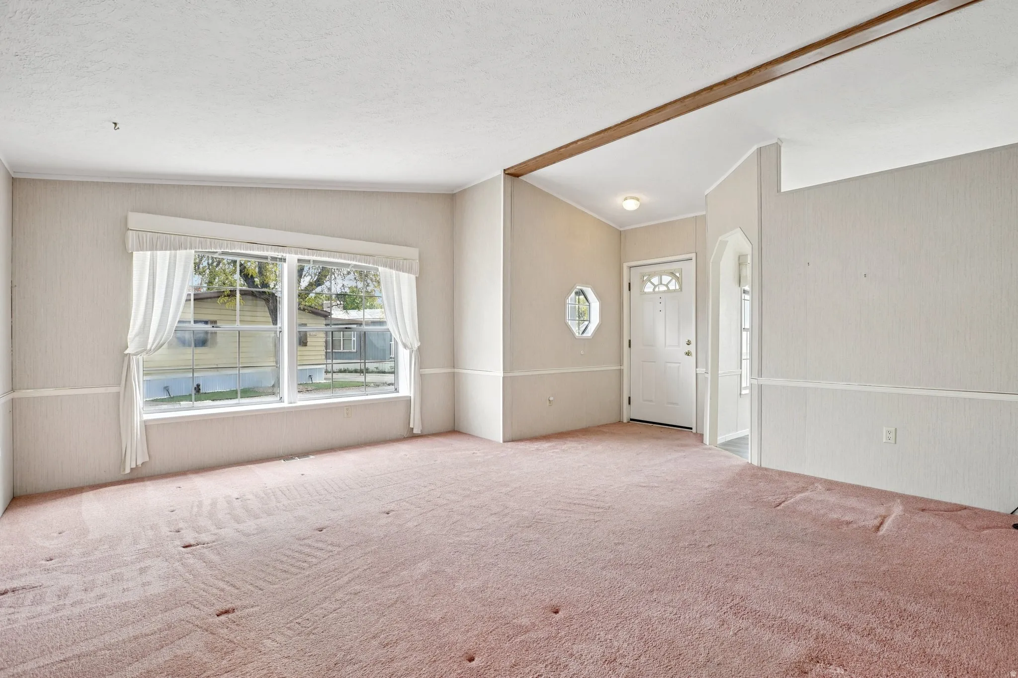 Carpeted spare room featuring arched walkways