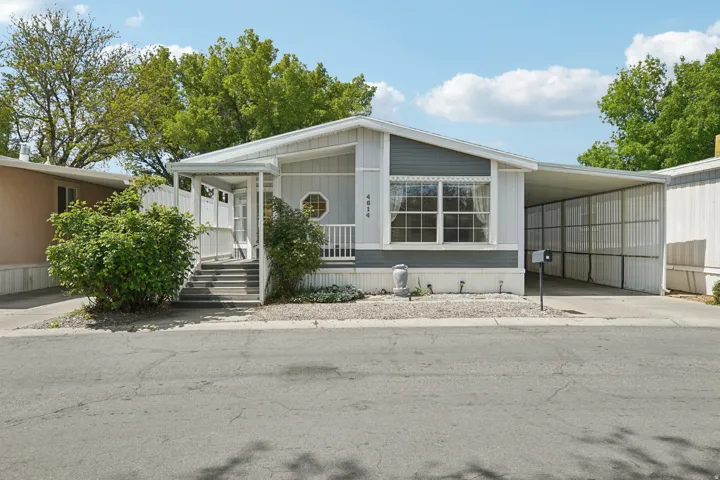 Manufactured / mobile home with a carport, covered porch, and driveway
