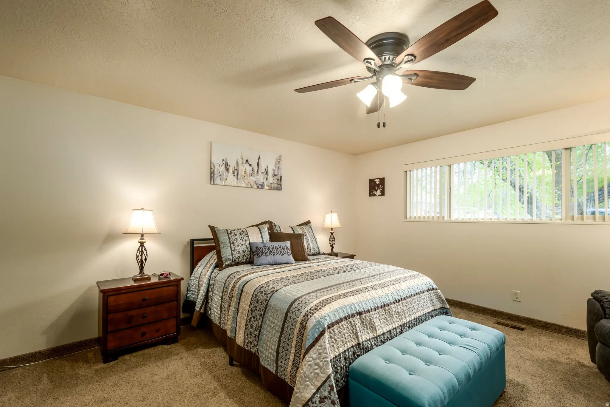 Carpeted bedroom with a textured ceiling and a ceiling fan