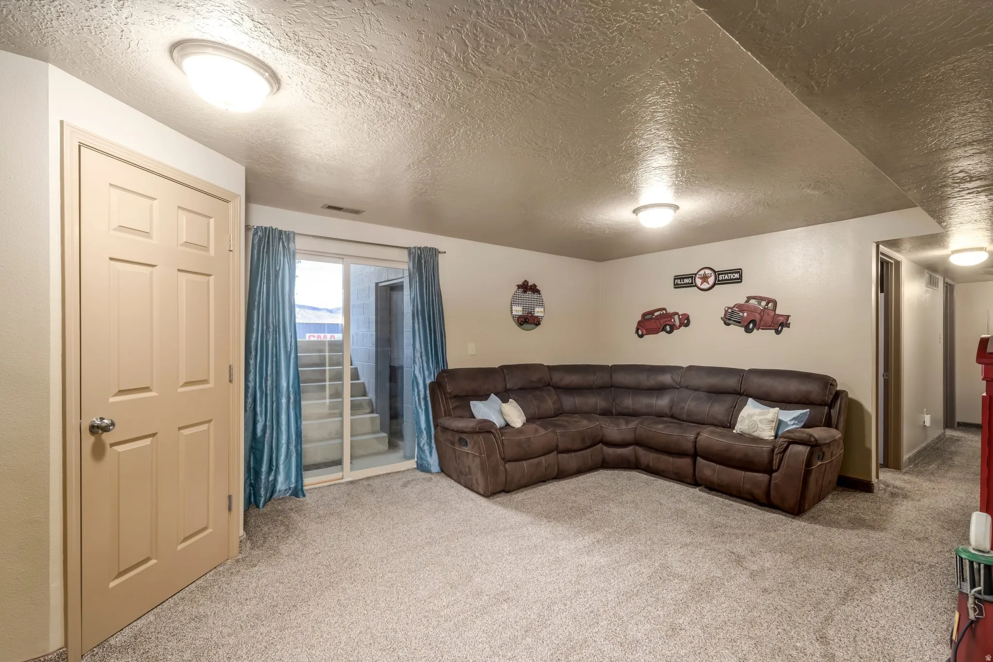 Living room with a textured ceiling and carpet floors