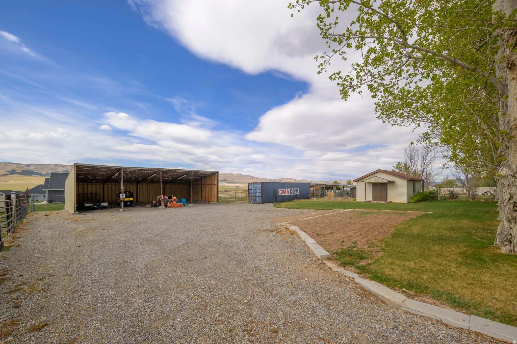 View of pole building with a mountain view, a detached carport, and driveway