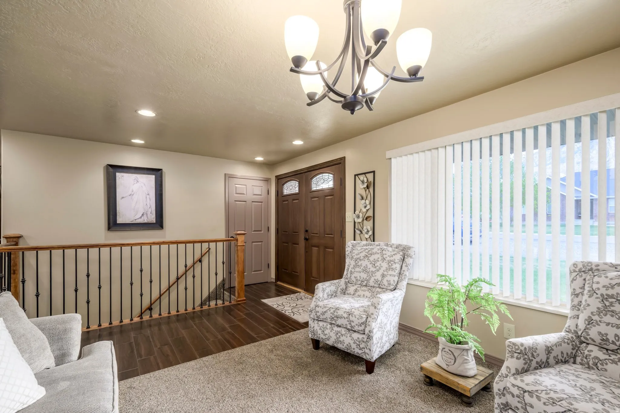 Sitting room with an upstairs landing, dark wood finished floors, a textured ceiling, and suspended lighting