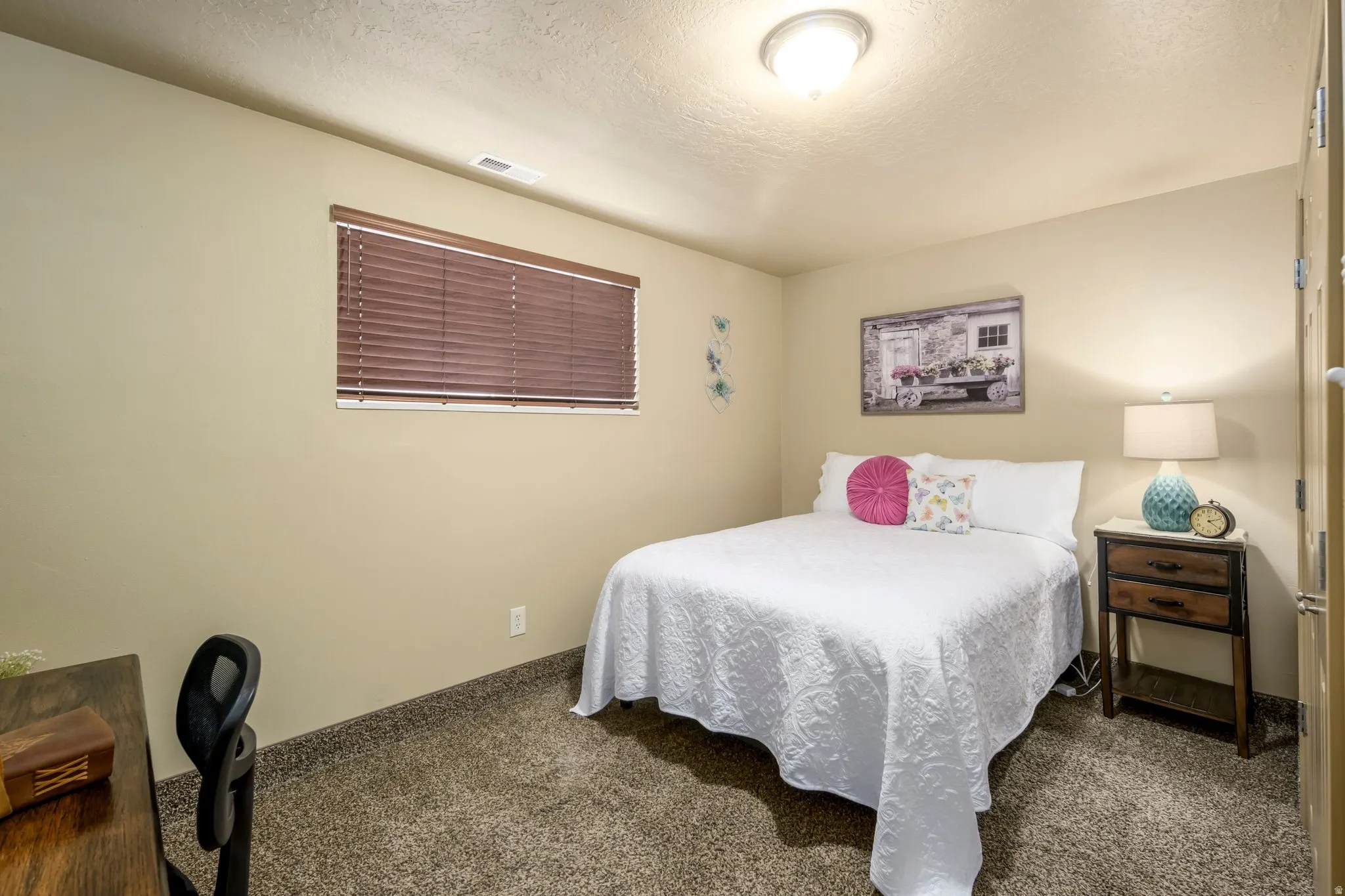 Bedroom featuring carpet and a textured ceiling