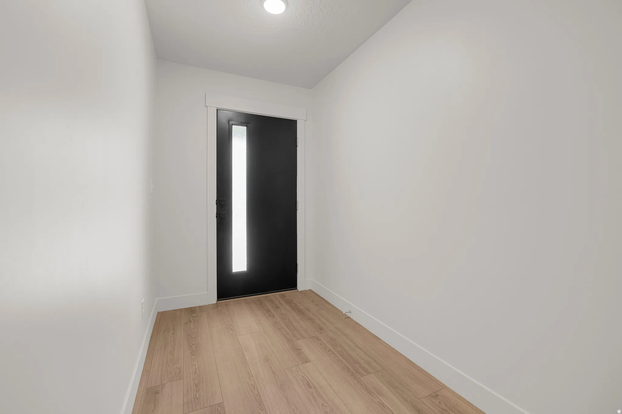 Entrance foyer featuring baseboards and light wood-style flooring