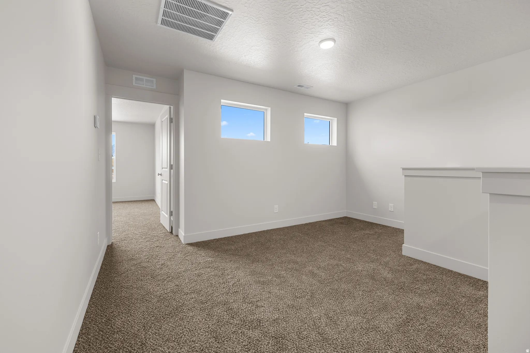 Unfurnished room with dark carpet and a textured ceiling