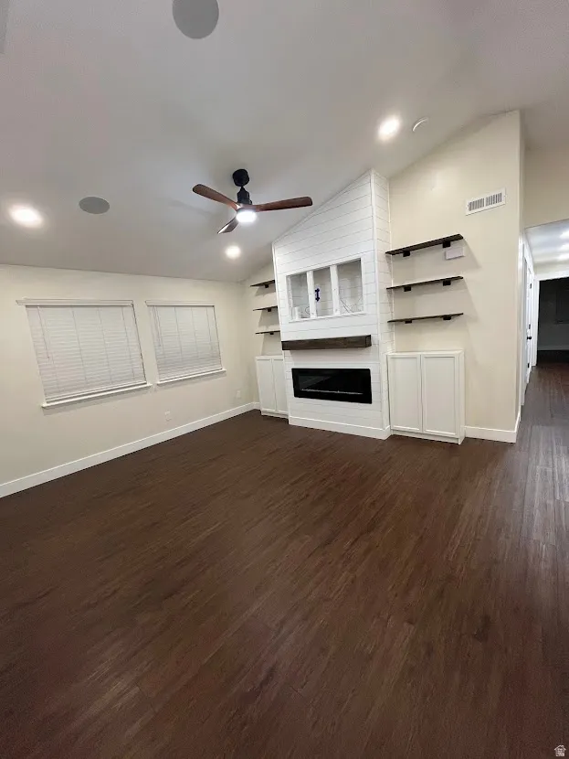 Living room featuring an built in entertainment center, electric fireplace, vaulted ceiling, ceiling fan, and recessed lighting