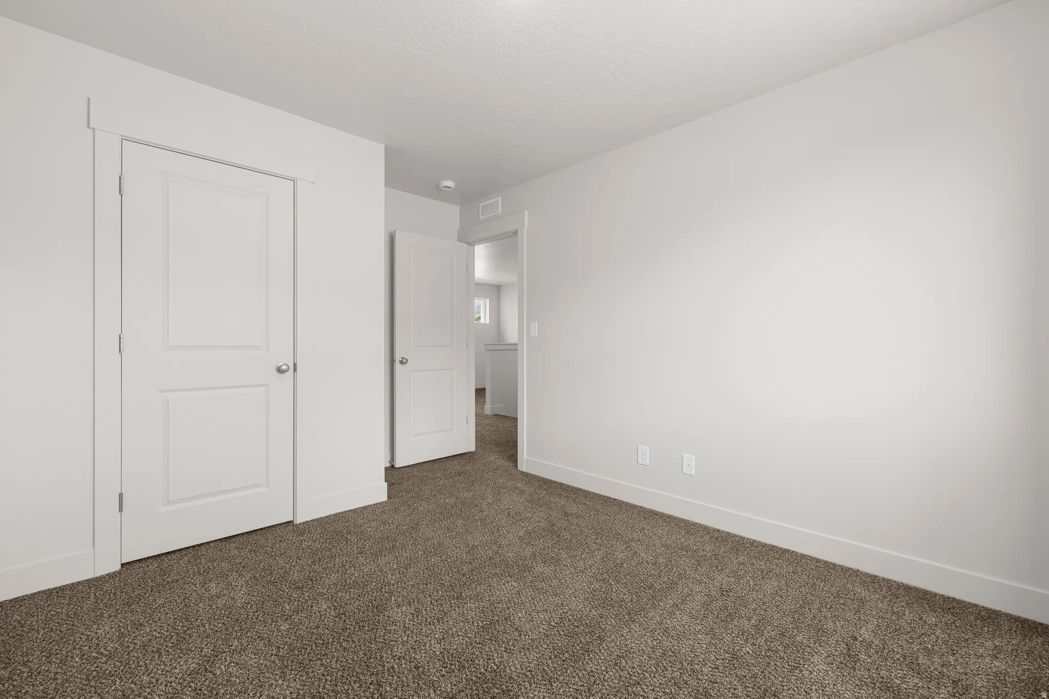Unfurnished bedroom with dark carpet and a closet