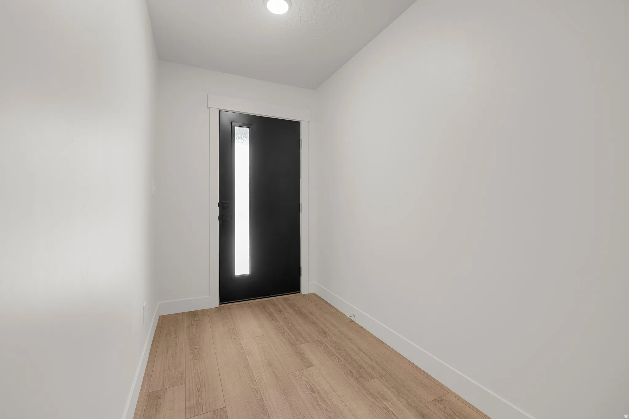 Entrance foyer featuring baseboards and light wood-type flooring
