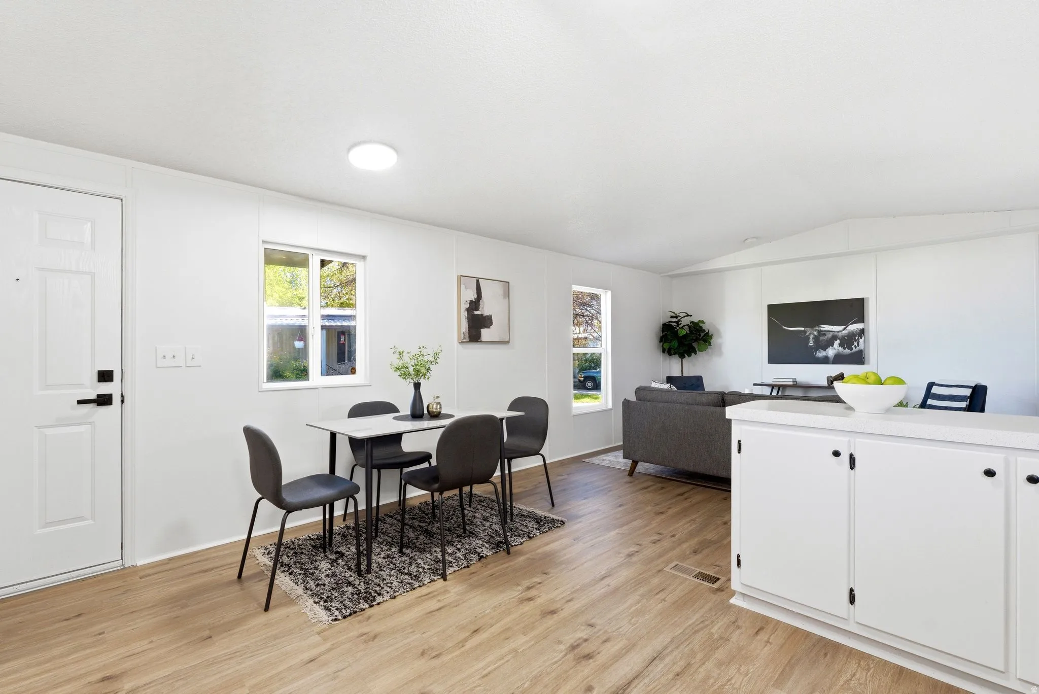 Dining room with light wood-style flooring and vaulted ceiling