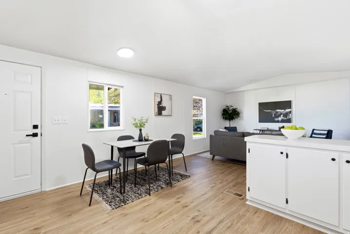 Dining room with light wood-style flooring and vaulted ceiling