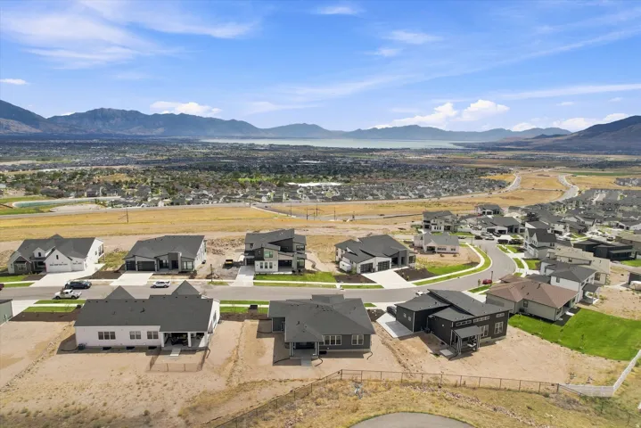New construction properties with modern architectural styles, surrounded by natural landscapes and distant mountains