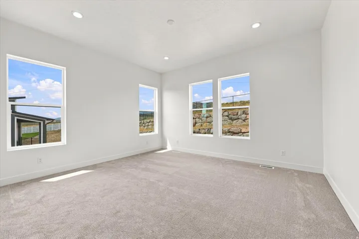 Recessed lighting, light gray carpeting, and multiple windows