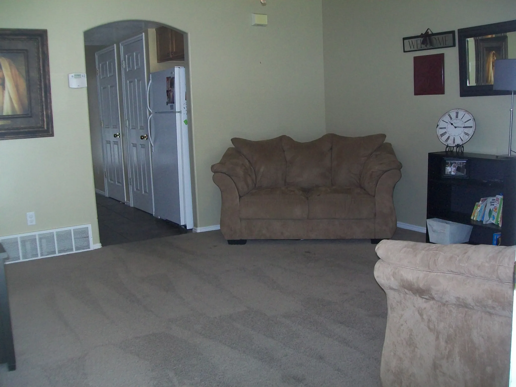 Living room featuring arched walkways and dark colored carpet