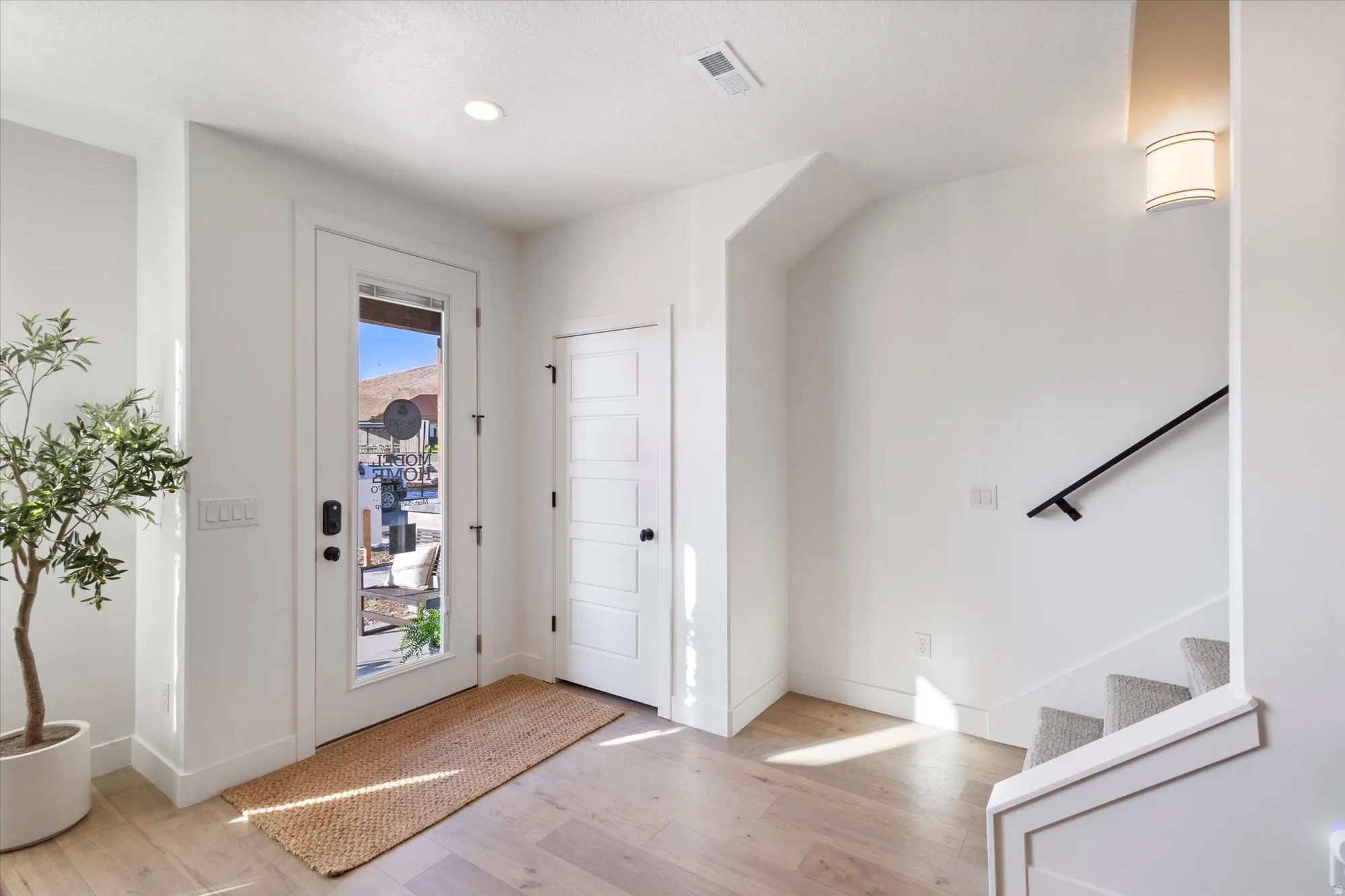 Entryway with light wood-style flooring and stairs
