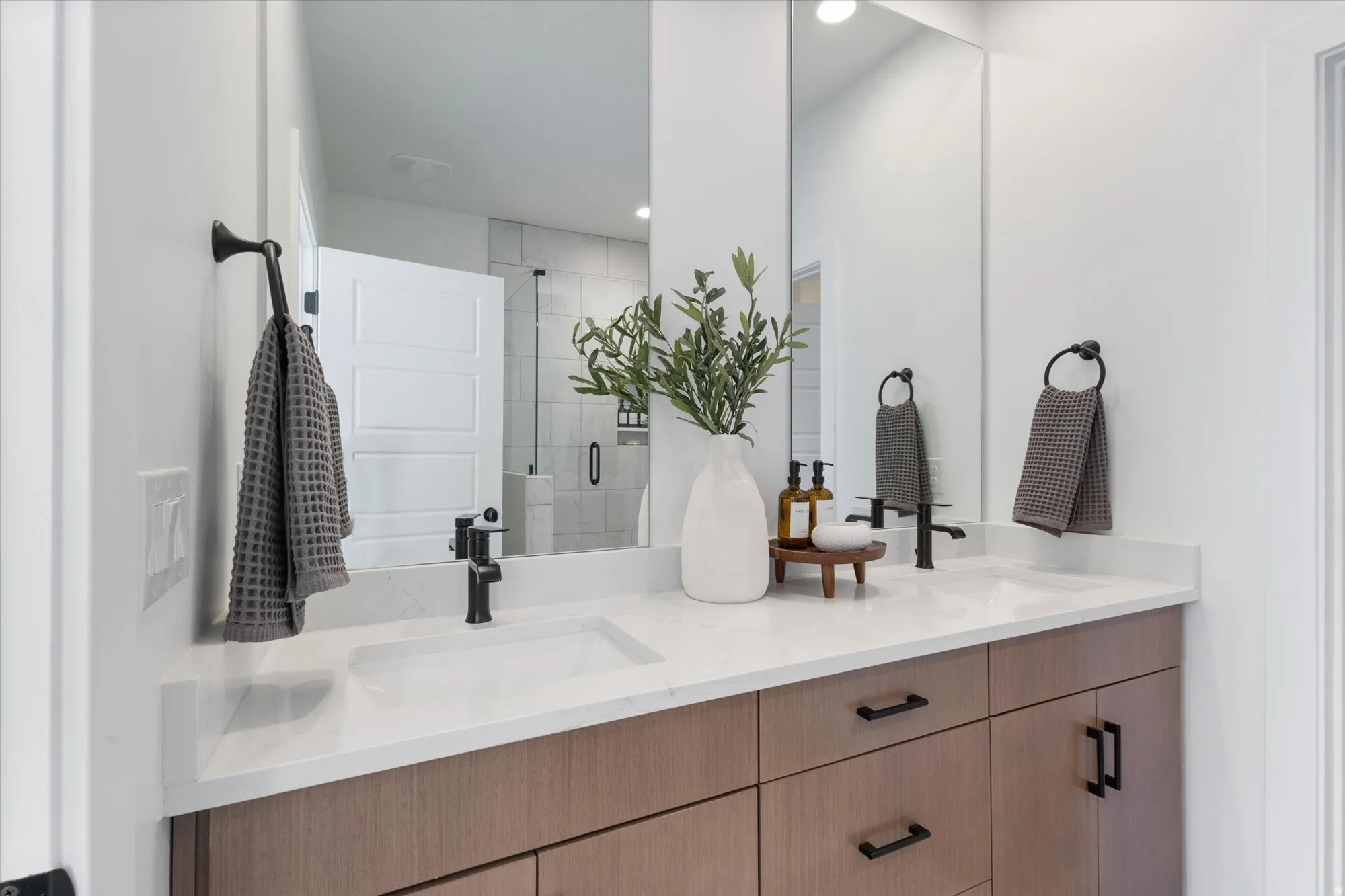 Bathroom featuring double vanity, a shower stall, and recessed lighting