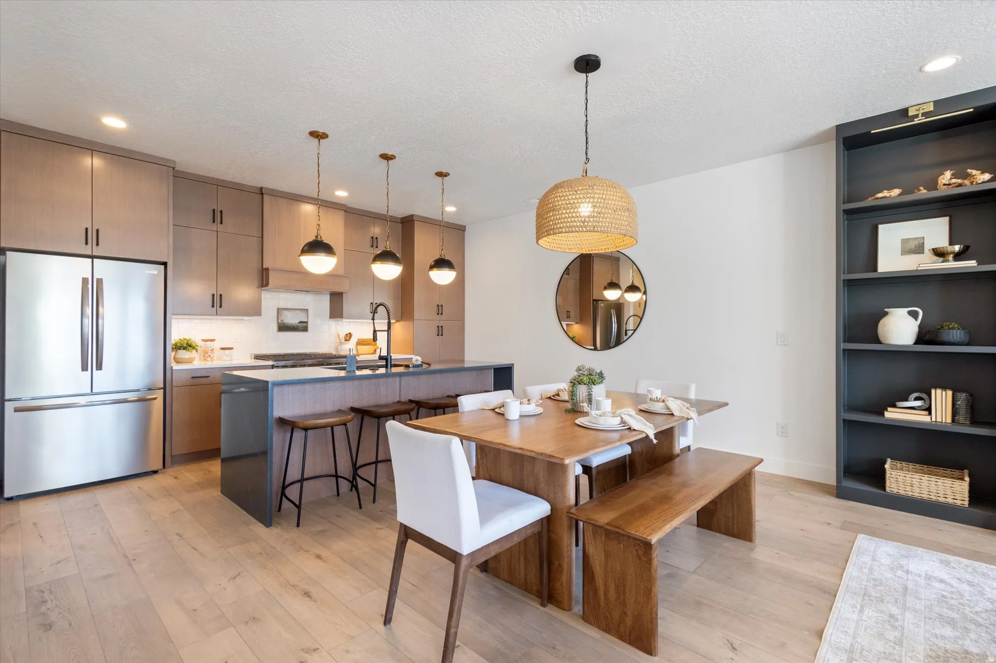 Dining space featuring light wood-style flooring, recessed lighting, and a textured ceiling