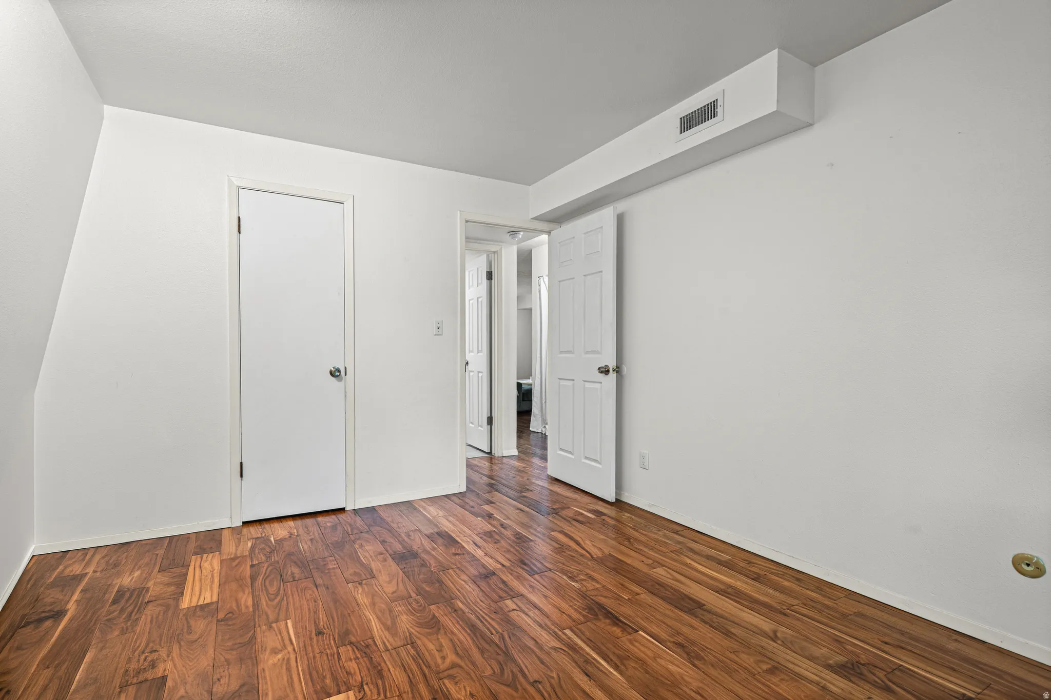 Unfurnished bedroom featuring hardwood flooring and baseboards