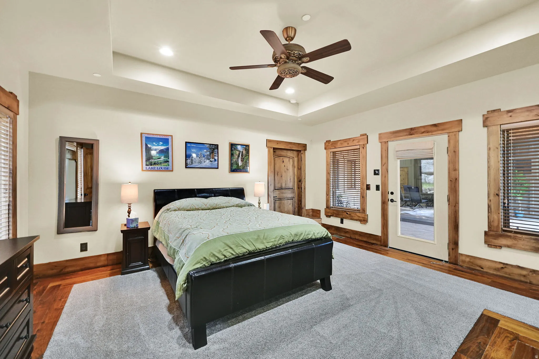 ADU Bedroom with access to outside, a ceiling fan, a tray ceiling, recessed lighting, and dark wood finished floors