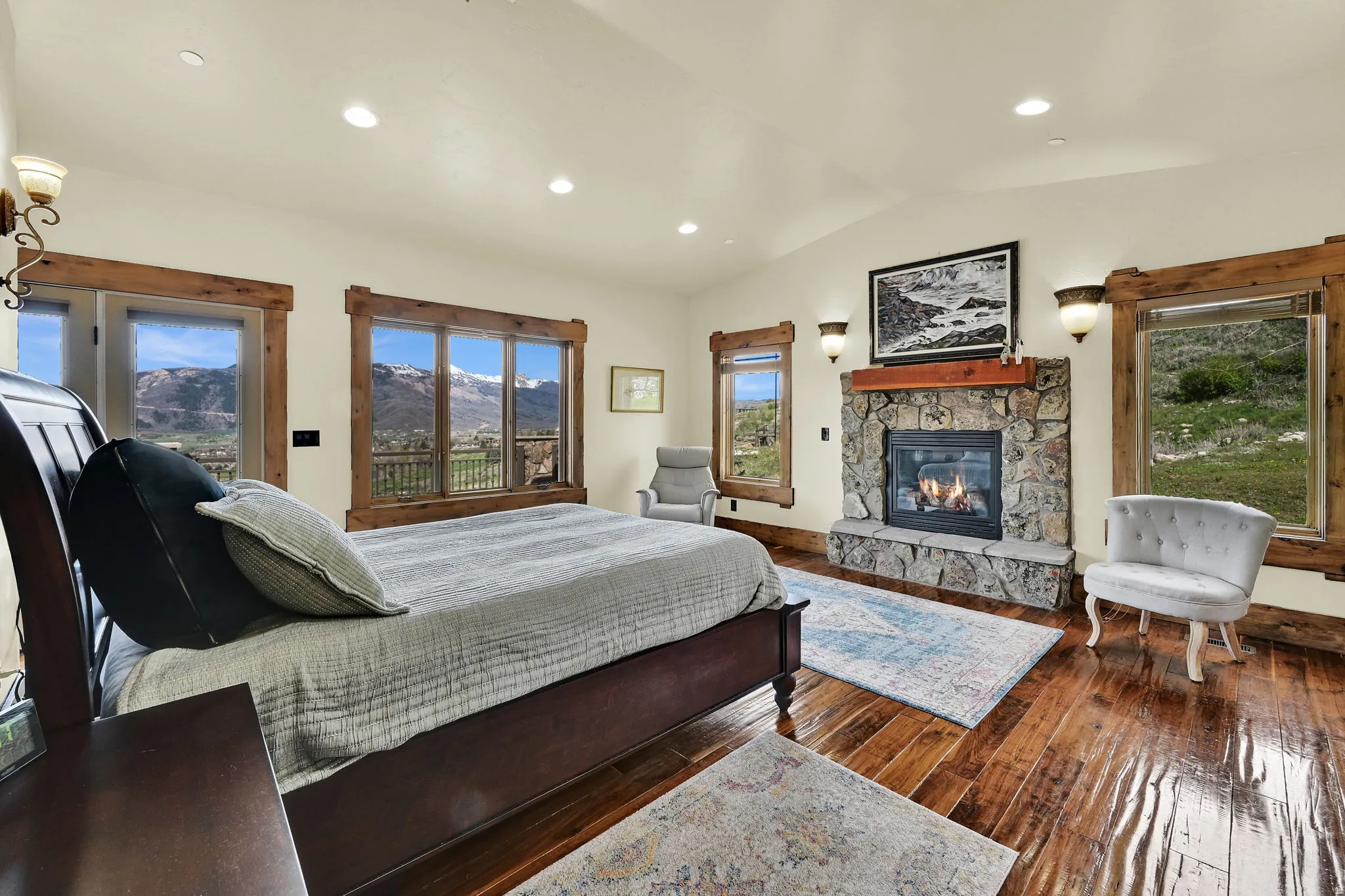 Bedroom featuring vaulted ceiling, dark wood-style floors, a fireplace, access to exterior, and recessed lighting