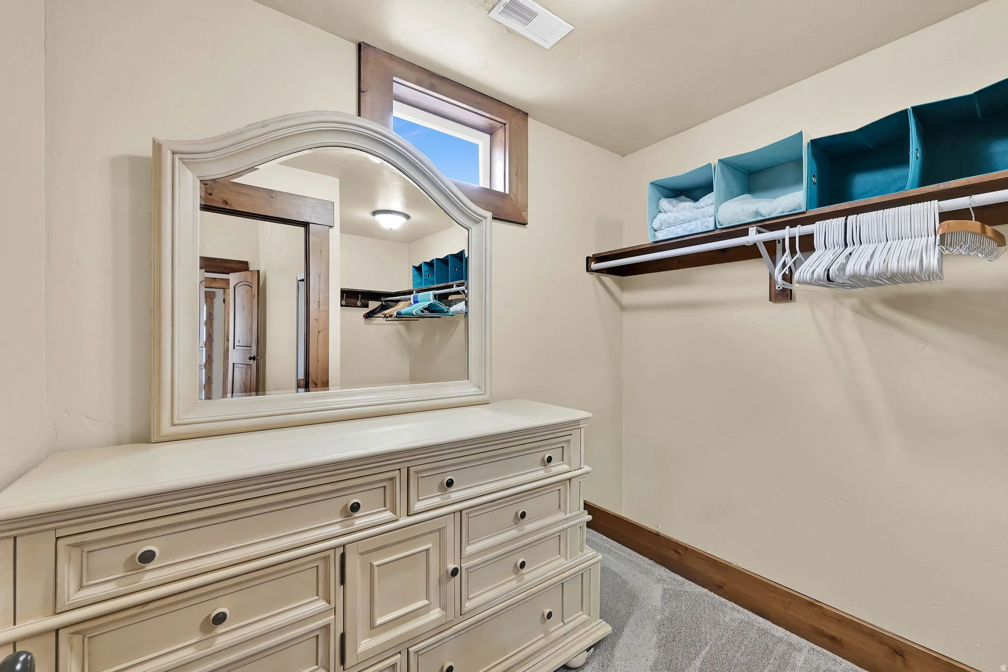 Walk in closet featuring dark colored carpet