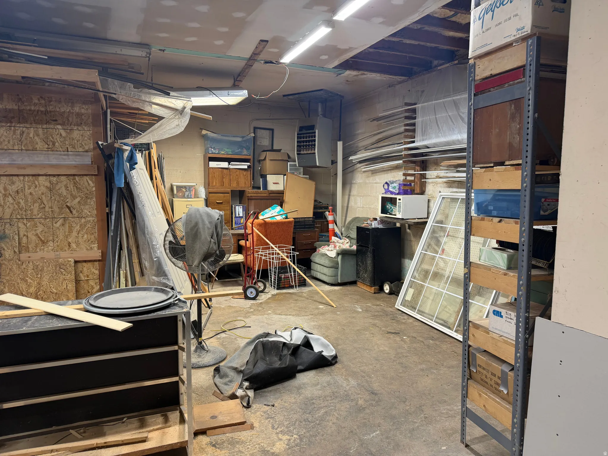 Below grade area featuring concrete block wall and a heating unit