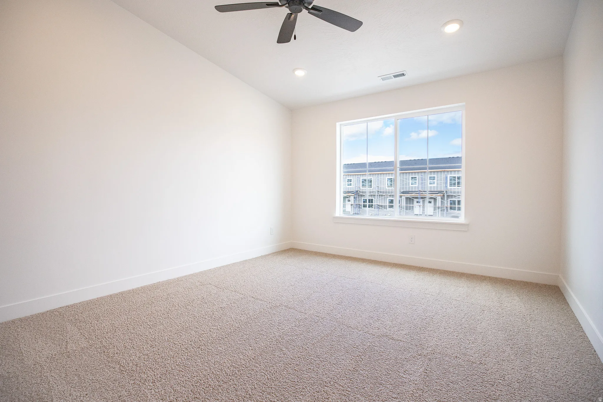 Primary bedroom with vaulted ceilings, recessed lighting, and a ceiling fan