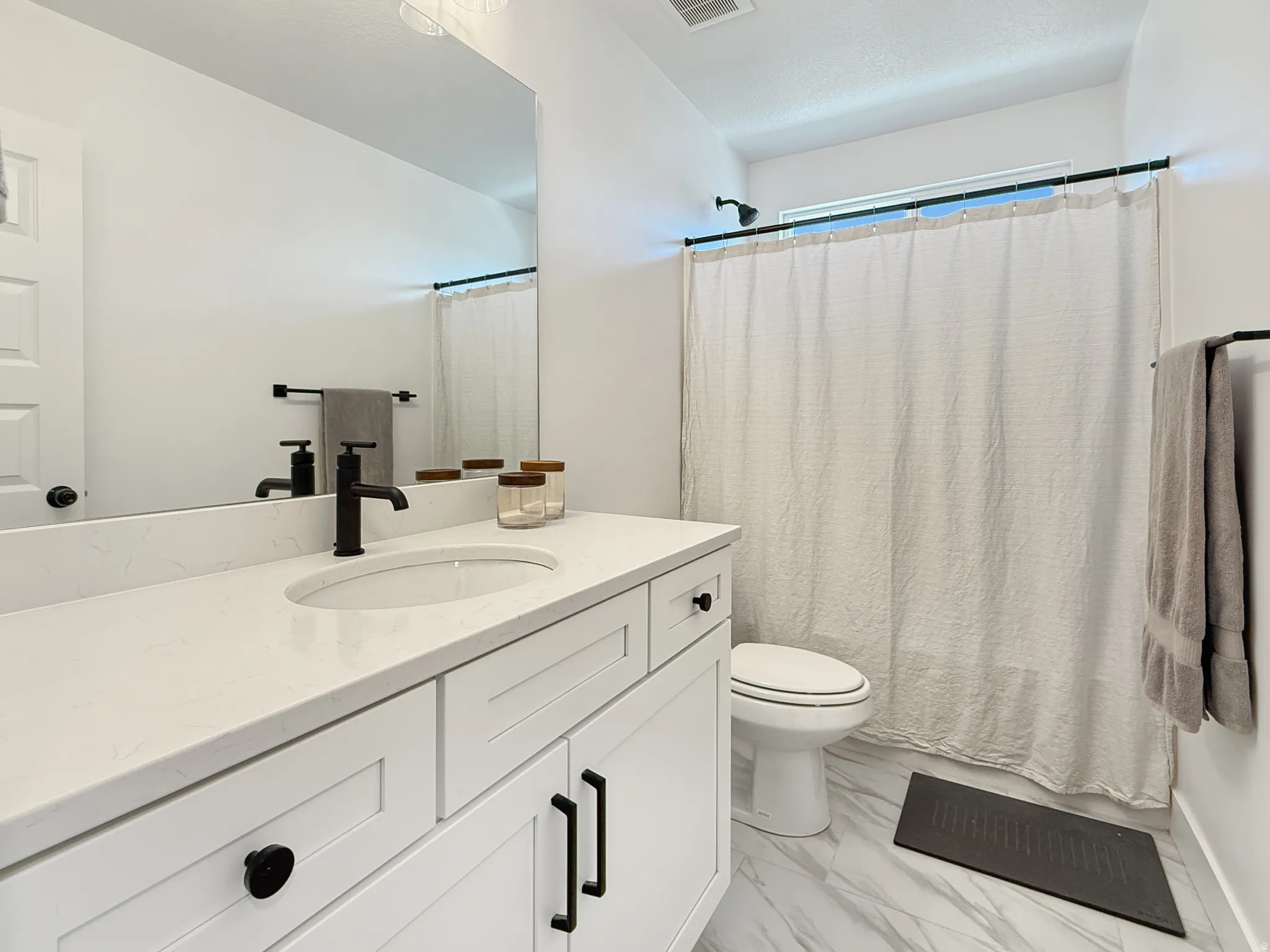 Full bathroom with vanity and light marble finish flooring