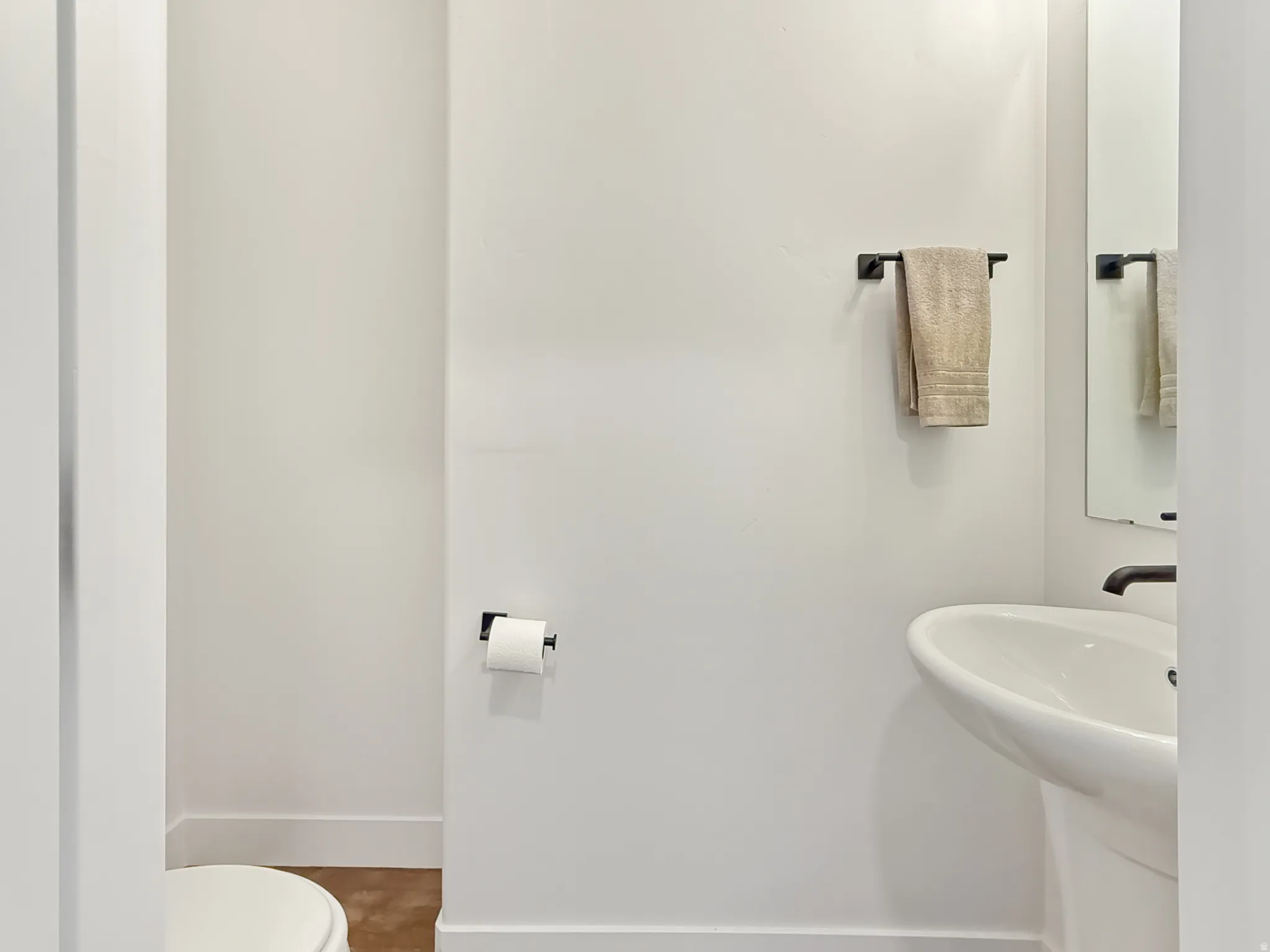 Half bathroom with toilet and baseboards