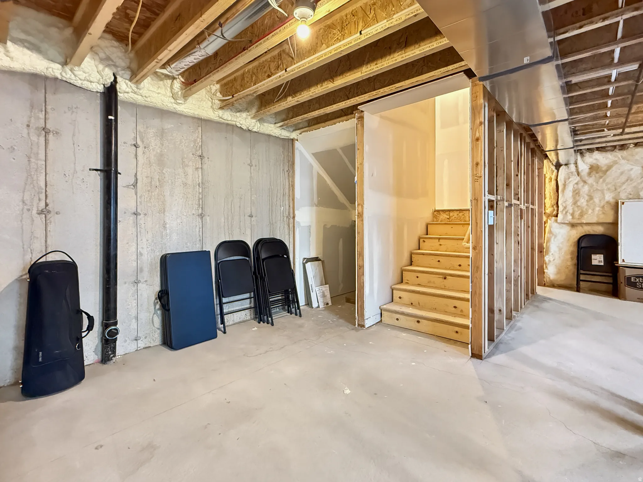 Unfinished below grade area featuring stairway