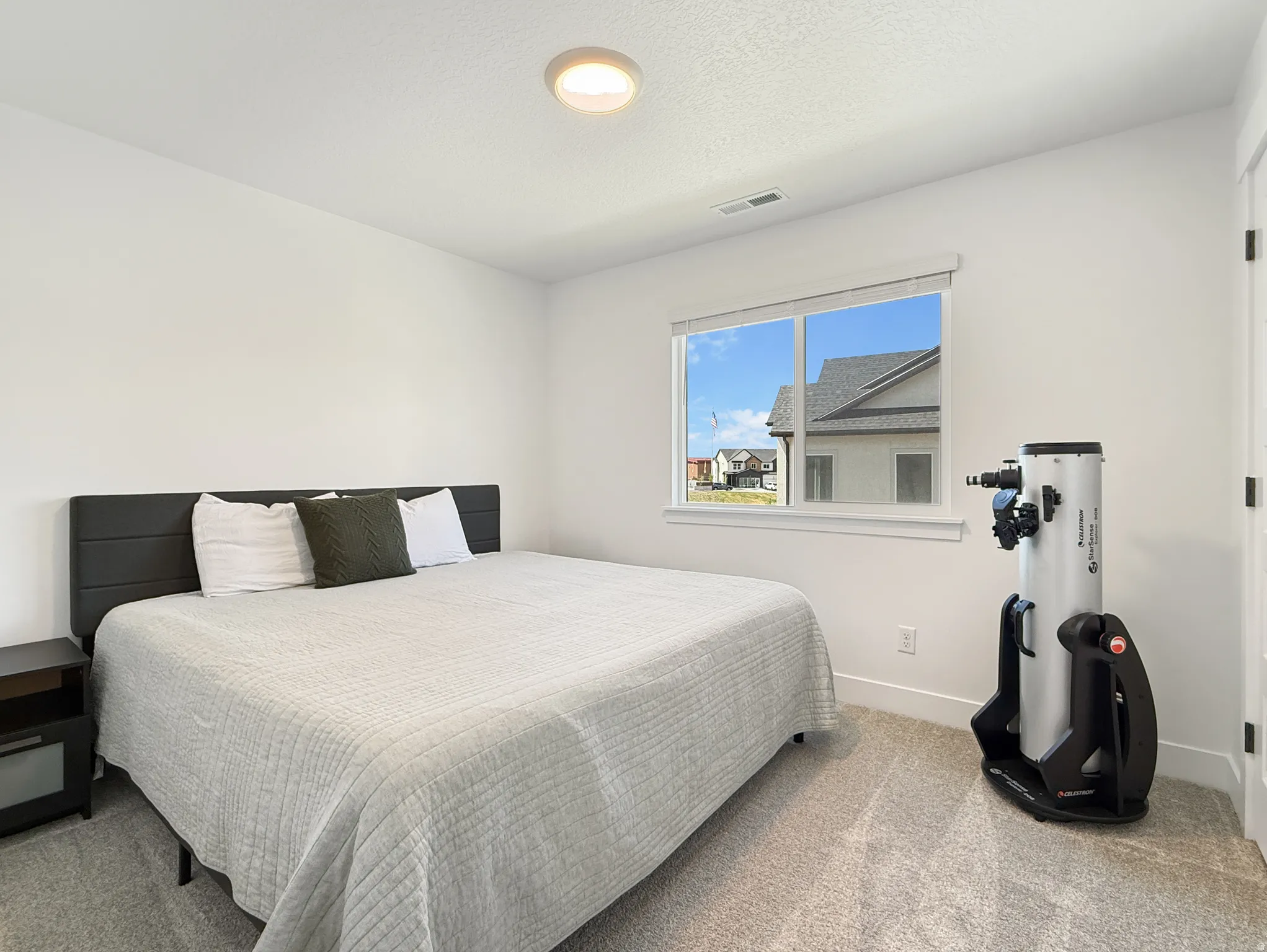 Carpeted bedroom featuring baseboards and a textured ceiling