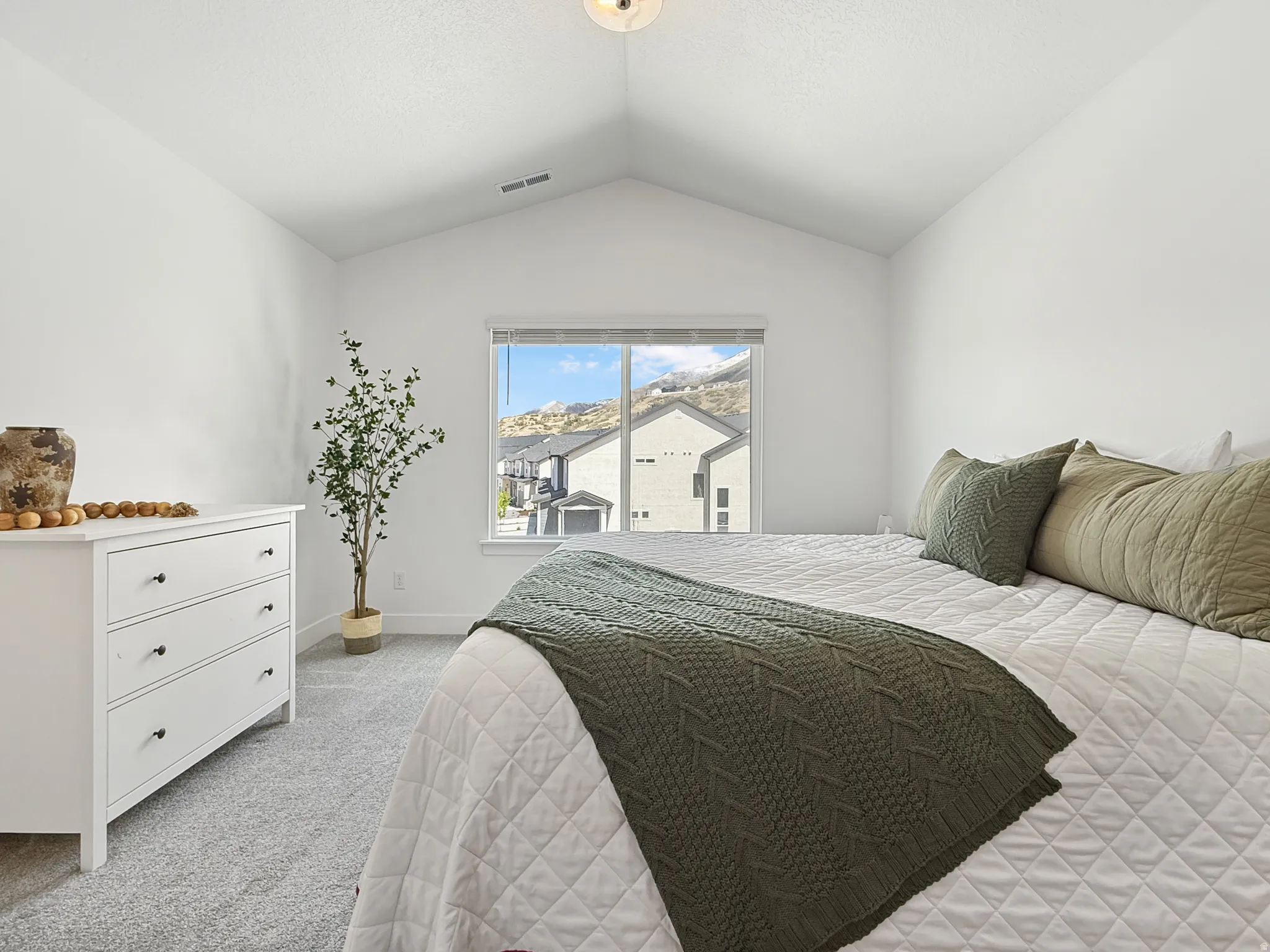 Bedroom with light colored carpet and baseboards
