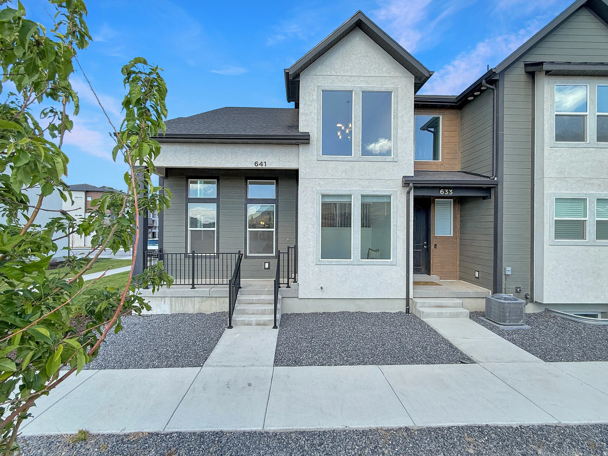 View of front of property with a shingled roof and stucco siding