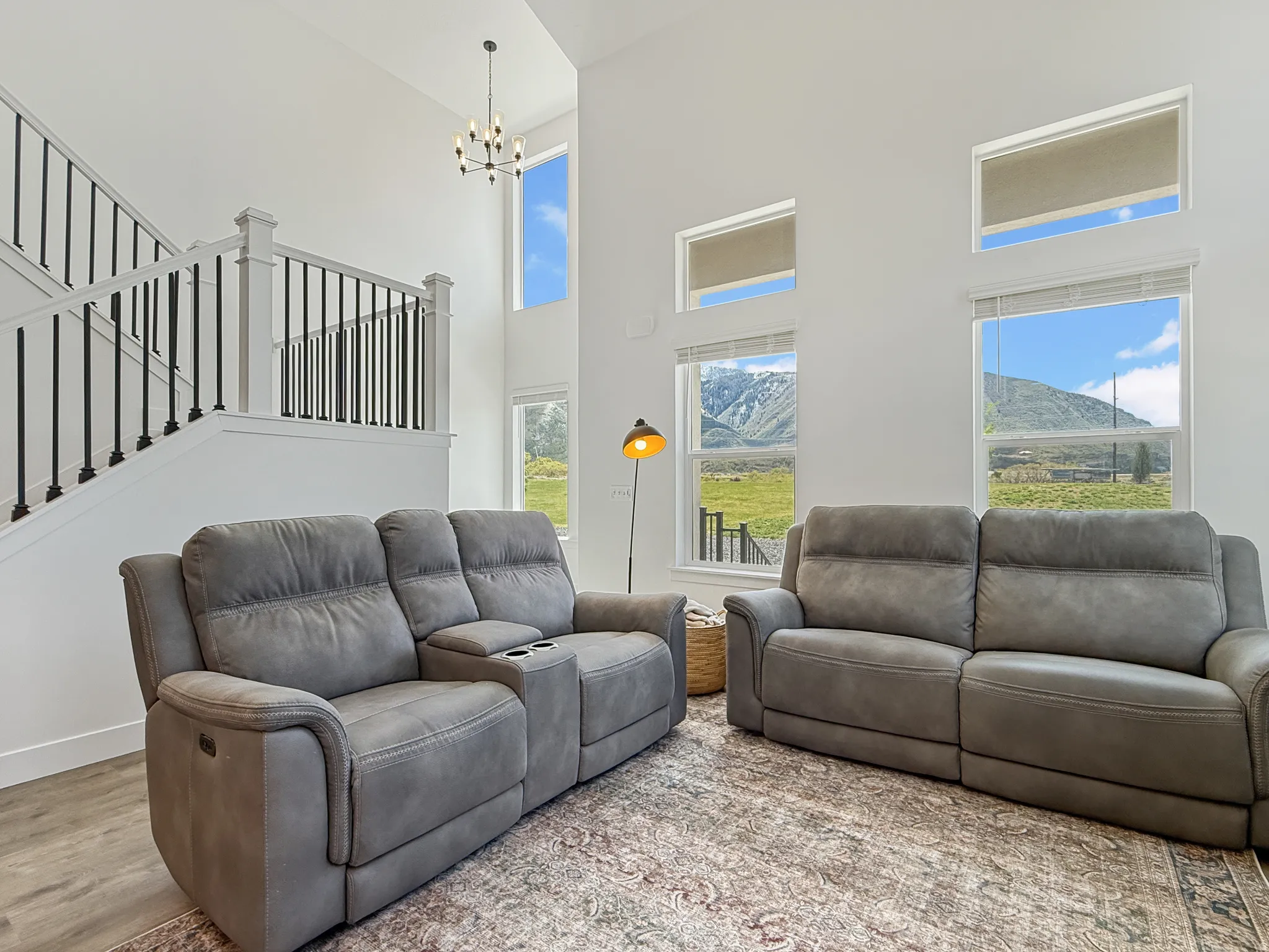 Living area featuring a high ceiling, light wood-style flooring, a chandelier, and a mountain view