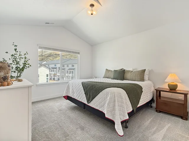 Bedroom featuring light carpet and baseboards