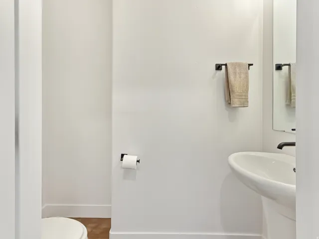 Half bathroom with toilet and baseboards