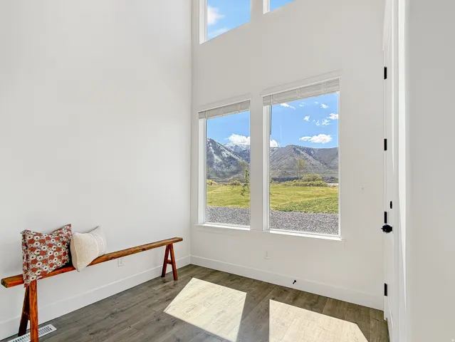 Interior space with dark wood-style flooring, a high ceiling, and a mountain view