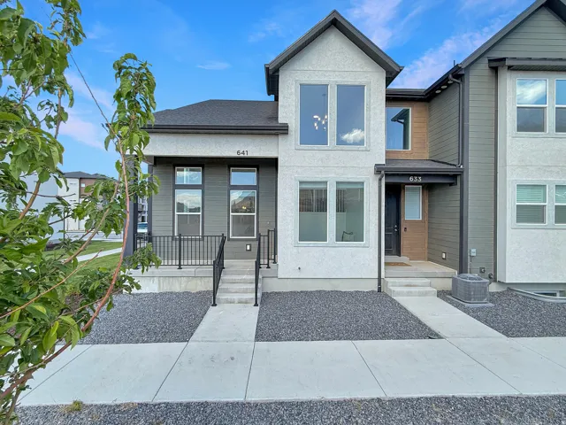 View of front of property with a shingled roof and stucco siding