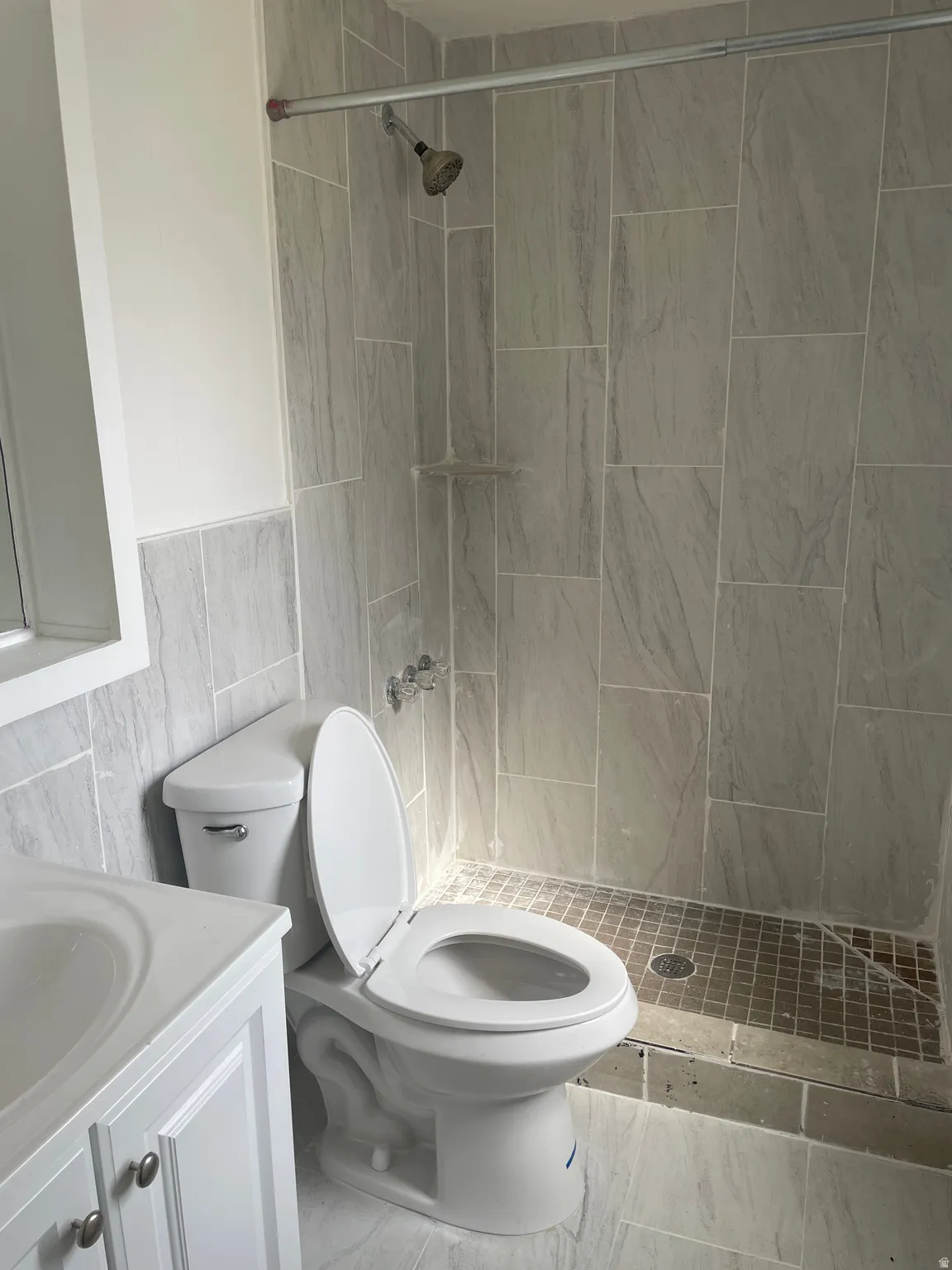 Bathroom with vanity, tile walls, and a stall shower