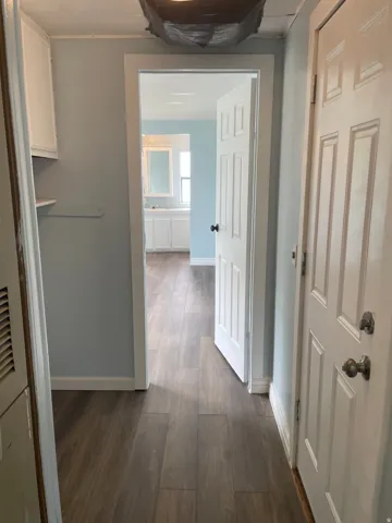 Corridor featuring dark wood finished floors and baseboards