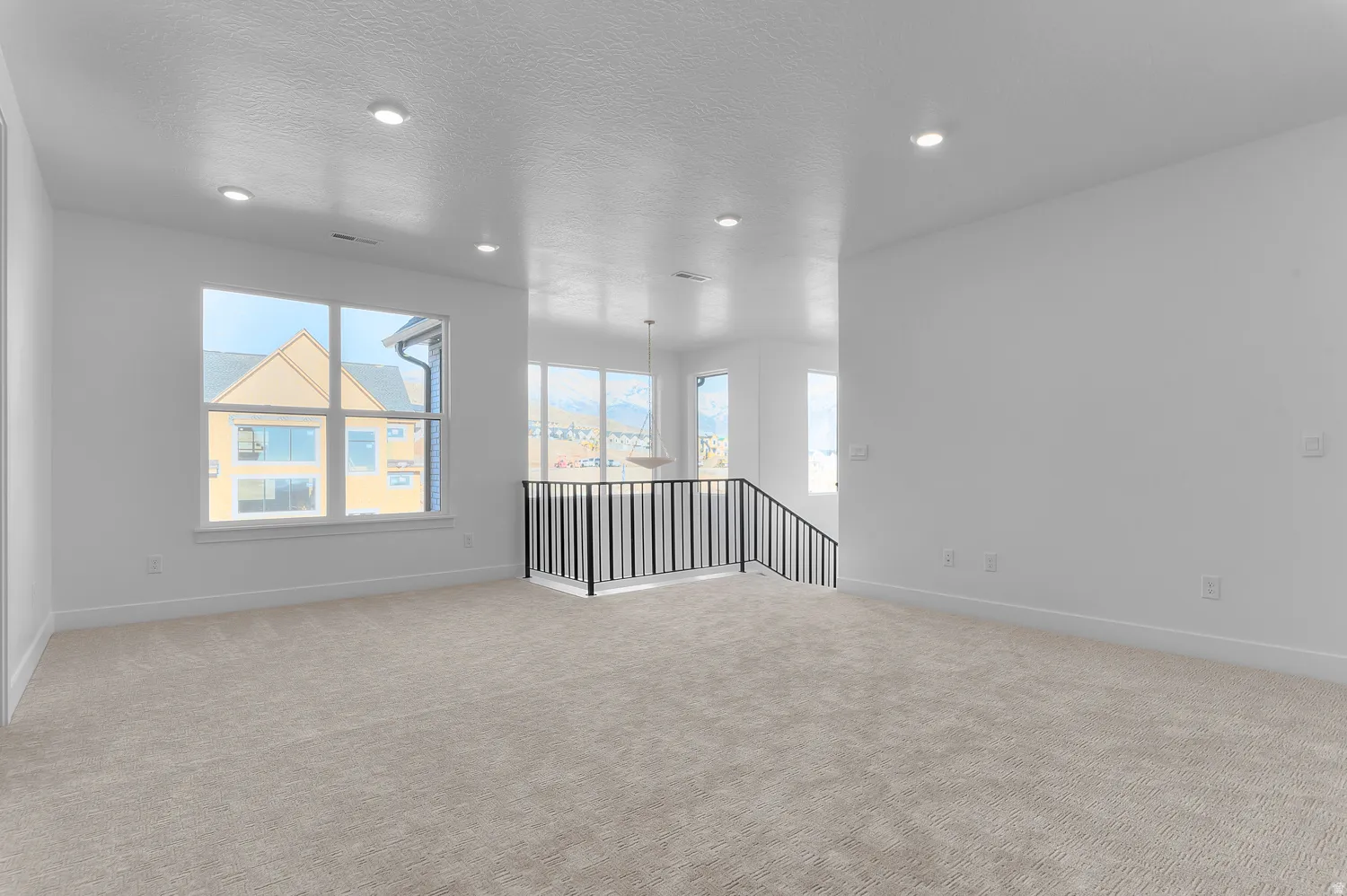Spare room featuring light colored carpet, recessed lighting, and a textured ceiling